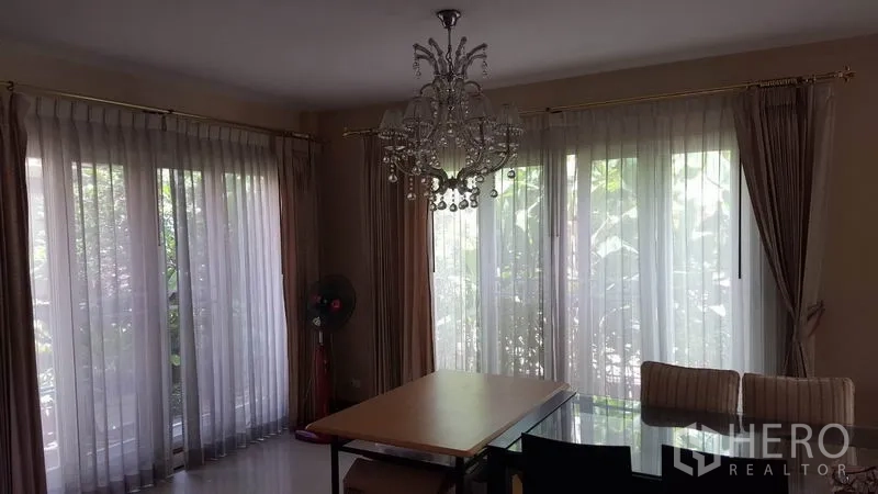 บ้าน ขายในMueang Nonthaburi, Nonthaburi - มุมรับประทานอาหารพร้อมโคมไฟแชนเดอเลียร์ หน้าต่างบานใหญ่ และโต๊ะกระจก