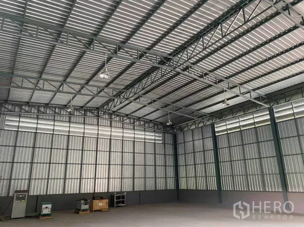 Warehouse for rent in Sam Phran, Nakhon Pathom - Spacious warehouse interior with 7m clear height, steel truss roof and high side windows for ventilation.