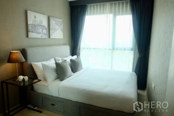 คอนโด ให้เช่าในKhlong Toei, Bangkok - ห้องนอนสว่างที่โครงการไลฟ์ คอนโดมิเนียม เตียงบุผ้า ผ้าม่านโปร่งและม่านทึบ พร้อมโคมไฟข้างเตียง