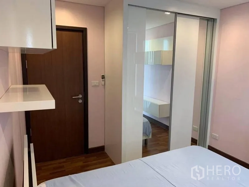 Condominium for rent in Watthana, Bangkok - Second bedroom angle showing sliding mirrored wardrobe and floating shelves.