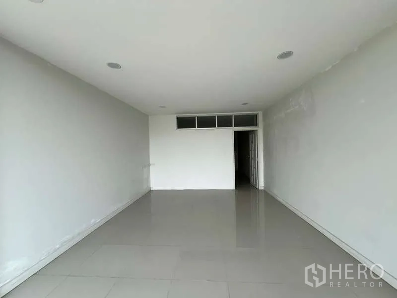 สำนักงานที่บ้าน ให้เช่าในSuan Luang, Bangkok - ห้องออฟฟิศโล่งขนาดใหญ่ ผนังสีกลาง พื้นกระเบื้อง และประตูมีช่องแสงด้านบน