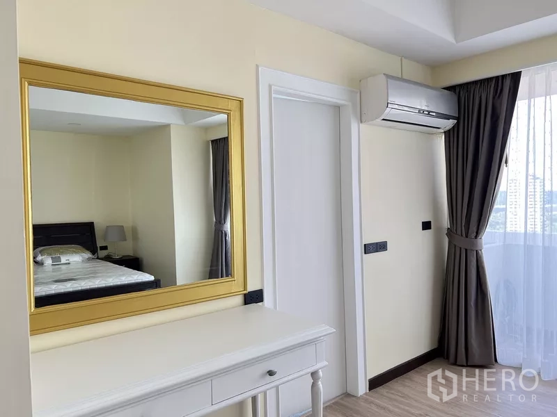 คอนโด ให้เช่าในKhlong Toei, Bangkok - มุมแต่งตัว กรอบกระจกสีทอง โต๊ะคอนโซลสีขาว เครื่องปรับอากาศ และหน้าต่างพร้อมผ้าม่าน