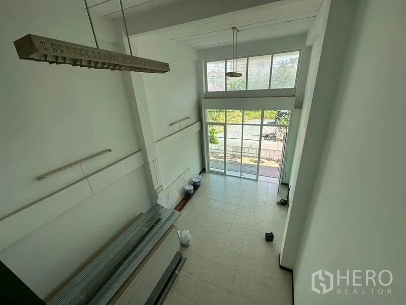 Home Office for rent in Phra Khanong, Bangkok - Double-height ground floor workspace with tiled floor and large sliding glass frontage letting in daylight.