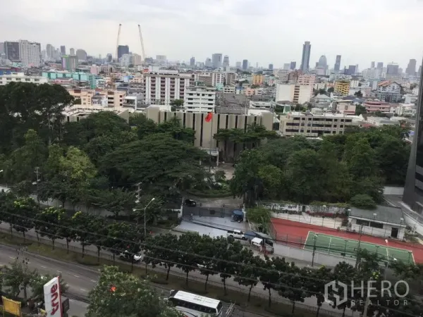 Condominium for rent in Huai Khwang, Bangkok - High-floor city view over Huai Khwang with mature trees, a tennis court and Bangkok skyline.