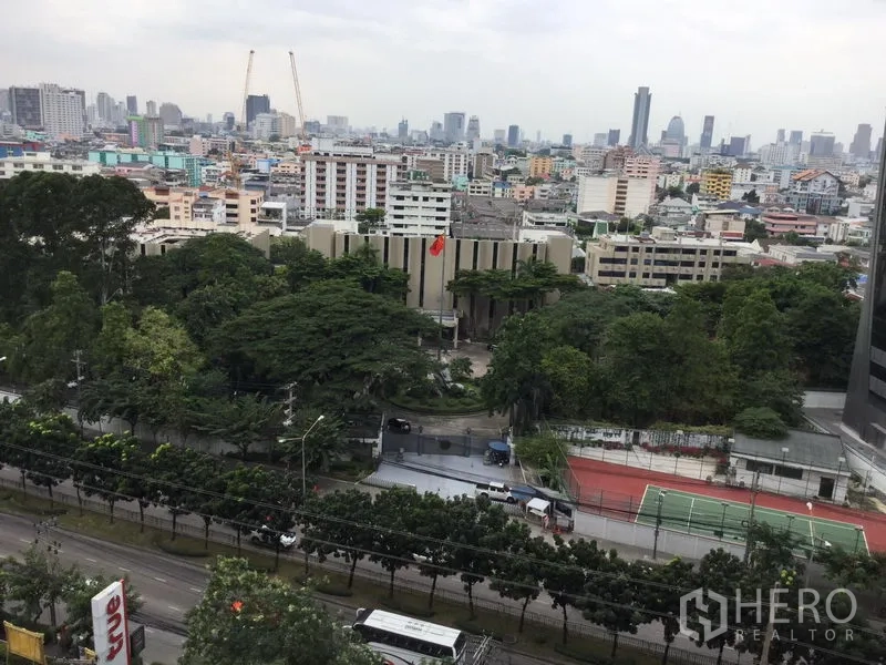Condominium for rent in Huai Khwang, Bangkok - High-floor city view over Huai Khwang with mature trees, a tennis court and Bangkok skyline.