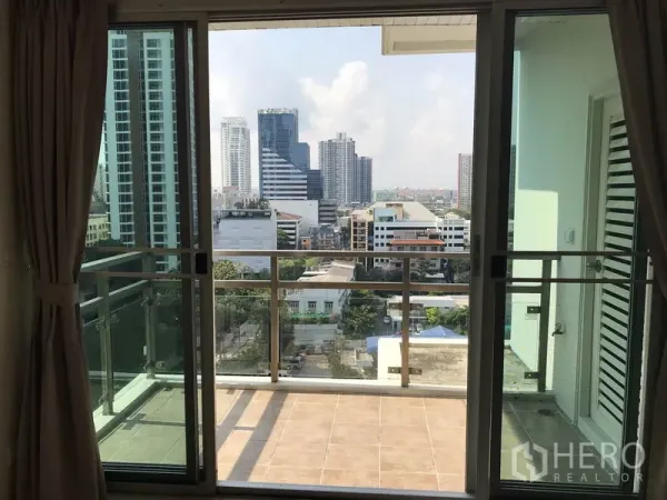 Condominium for rent in Khlong Toei, Bangkok - Balcony with glass railing looking out to the Ekkamai city skyline.