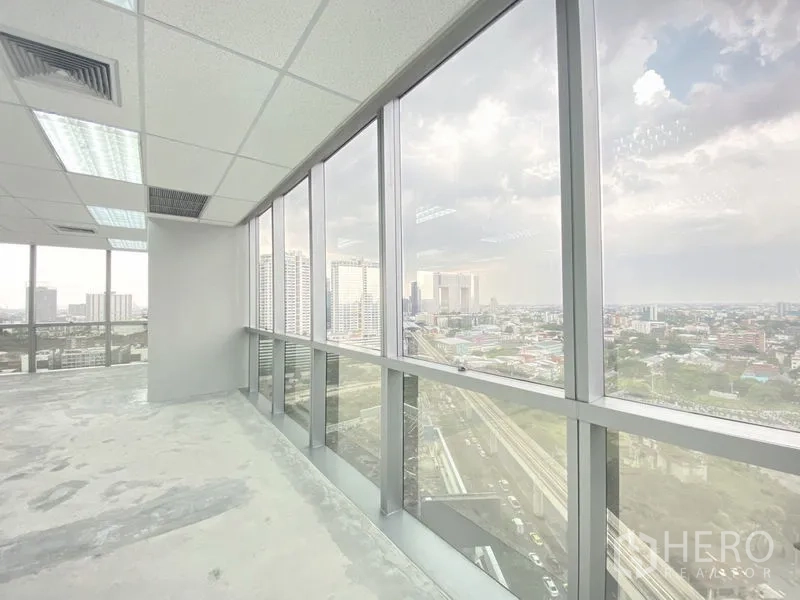 办公空间 出租在Chatuchak, Bangkok - 办公室内的落地窗带来曼谷天际线与高架轨道的景色。