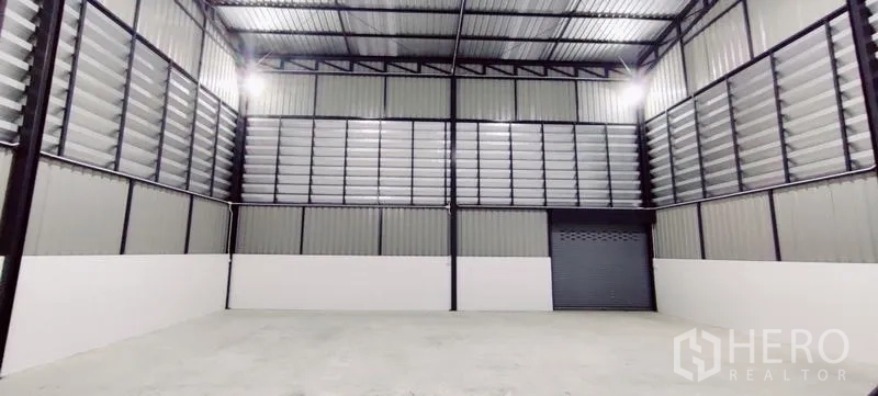 Warehouse for rent in Lam Luk Ka, Pathum Thani - Straight-on view of warehouse bay with roller door, tall walls and ventilated panels.