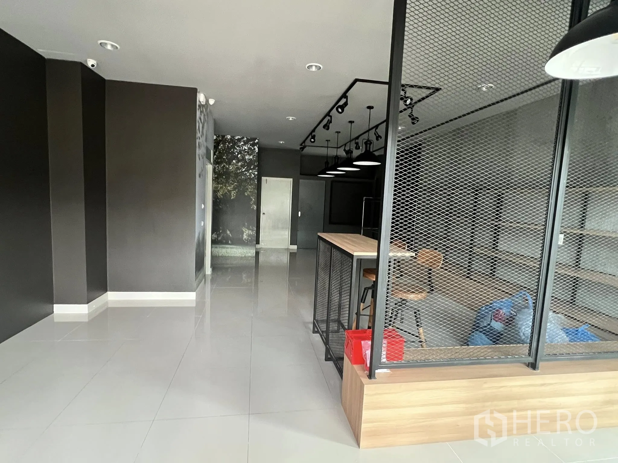 Detached House for rent or sale in Don Mueang, Bangkok - Showroom corridor with mesh divider and spotlight tracks.