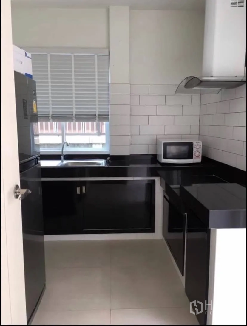 独立式住宅 出租或出售在Prawet, Bangkok - 封闭式泰式厨房，黑色台面、白色地铁砖墙与窗户。