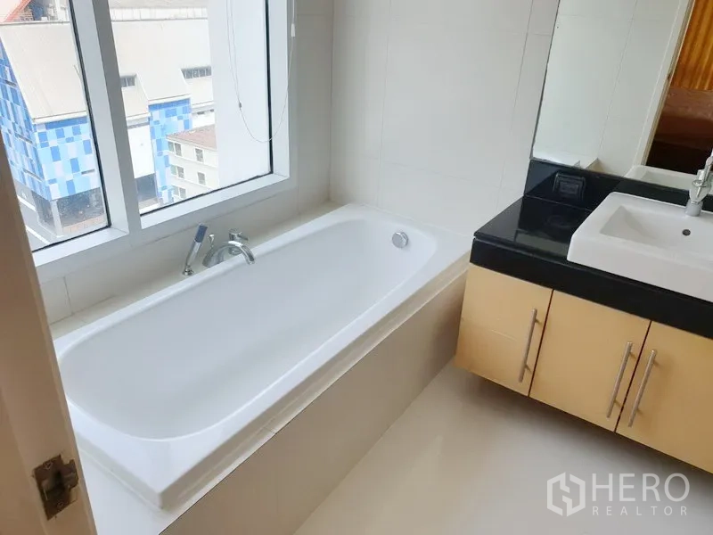 คอนโด ให้เช่าหรือขายในWatthana, Bangkok - ห้องน้ำมีอ่างอาบน้ำริมหน้าต่าง และเคาน์เตอร์หินสีดำพร้อมอ่างล้างหน้า