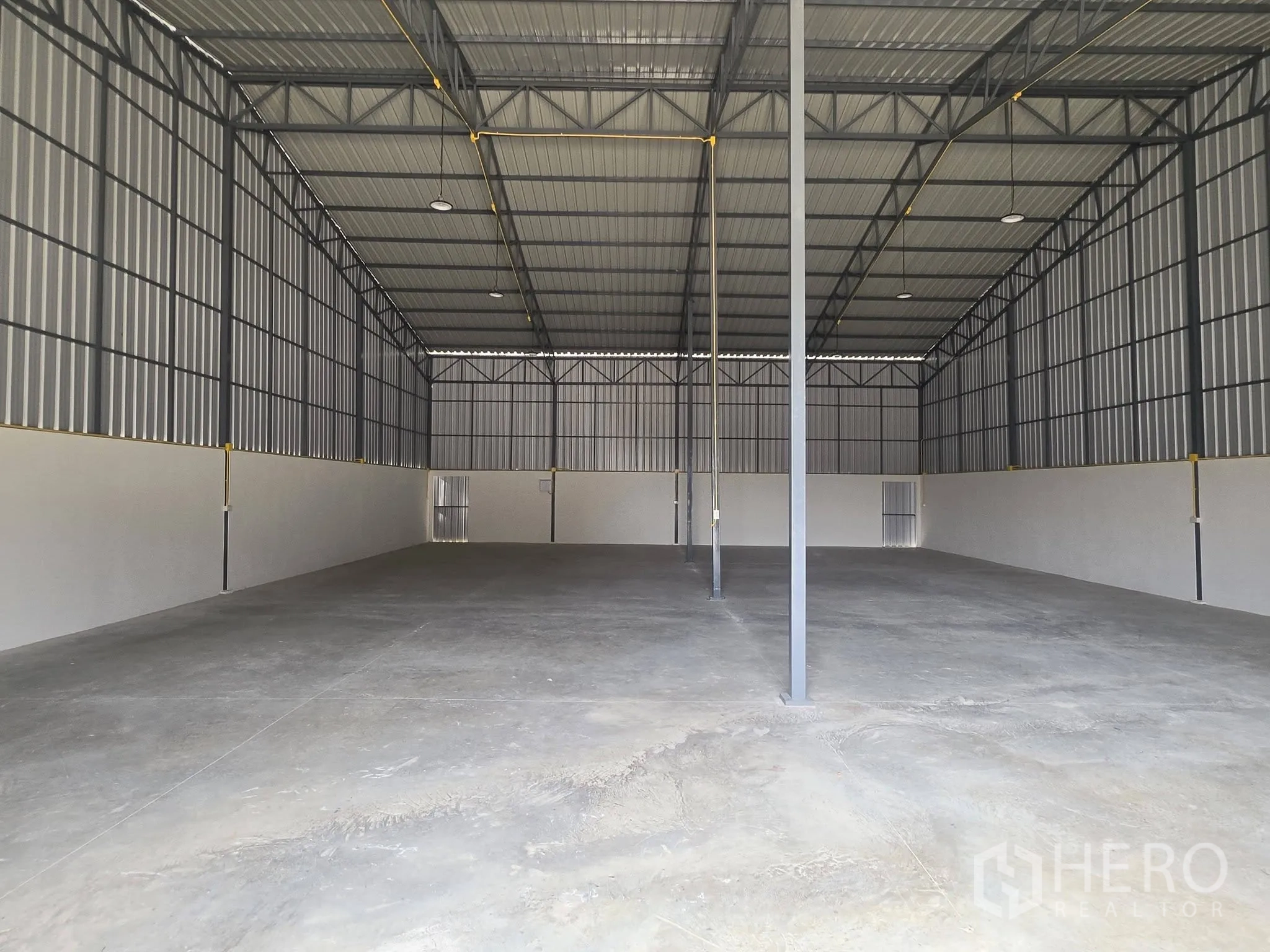 โกดัง for rent in Mueang Samut Prakan, Samut Prakan - พื้นที่โกดังโล่งติดไฟสว่าง เพดานสูง และมีเสารองรับหลายจุด