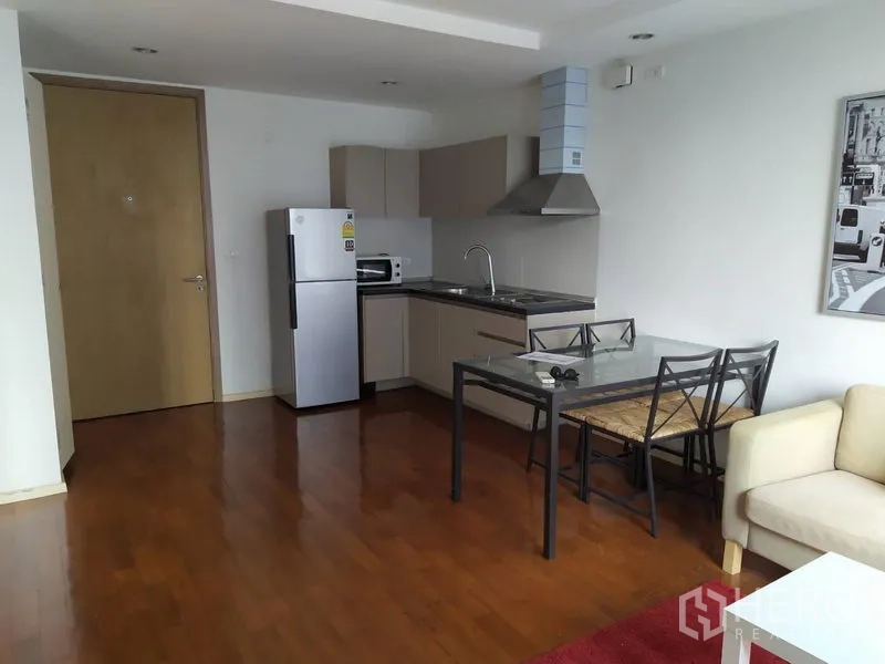 Condominium for sale in Khlong Toei, Bangkok - Spacious open-plan kitchen and dining area with wood floors and neutral cabinetry.
