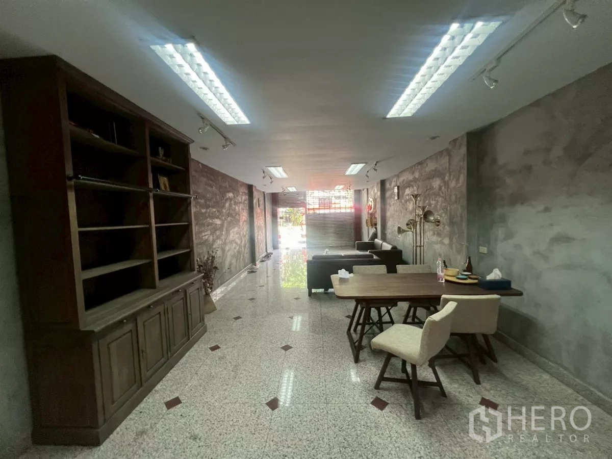 店屋 出租在Bang Rak, Bangkok - 由后往前的店内视角，内置柜、工作桌与前方卷闸门。