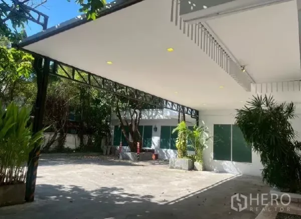 带办公室的家 出租在Watthana, Bangkok - 带顶棚的车位，内置筒灯，宽敞车道与绿植环绕。