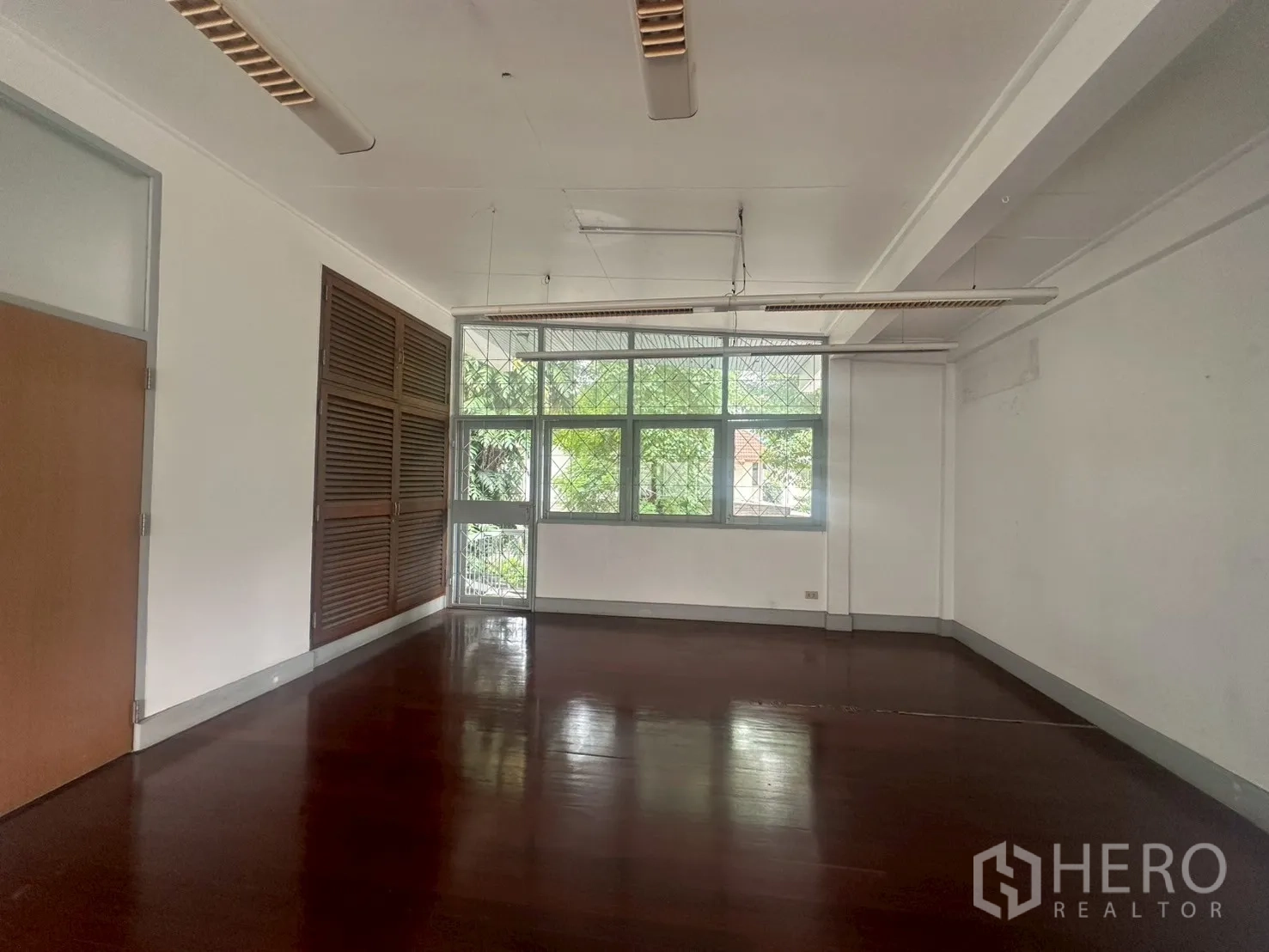 บ้าน ให้เช่าในWatthana, Bangkok - ห้องชั้นบนอีกห้อง มีตู้บานเกล็ดและหน้าต่างบานใหญ่เห็นวิวต้นไม้.