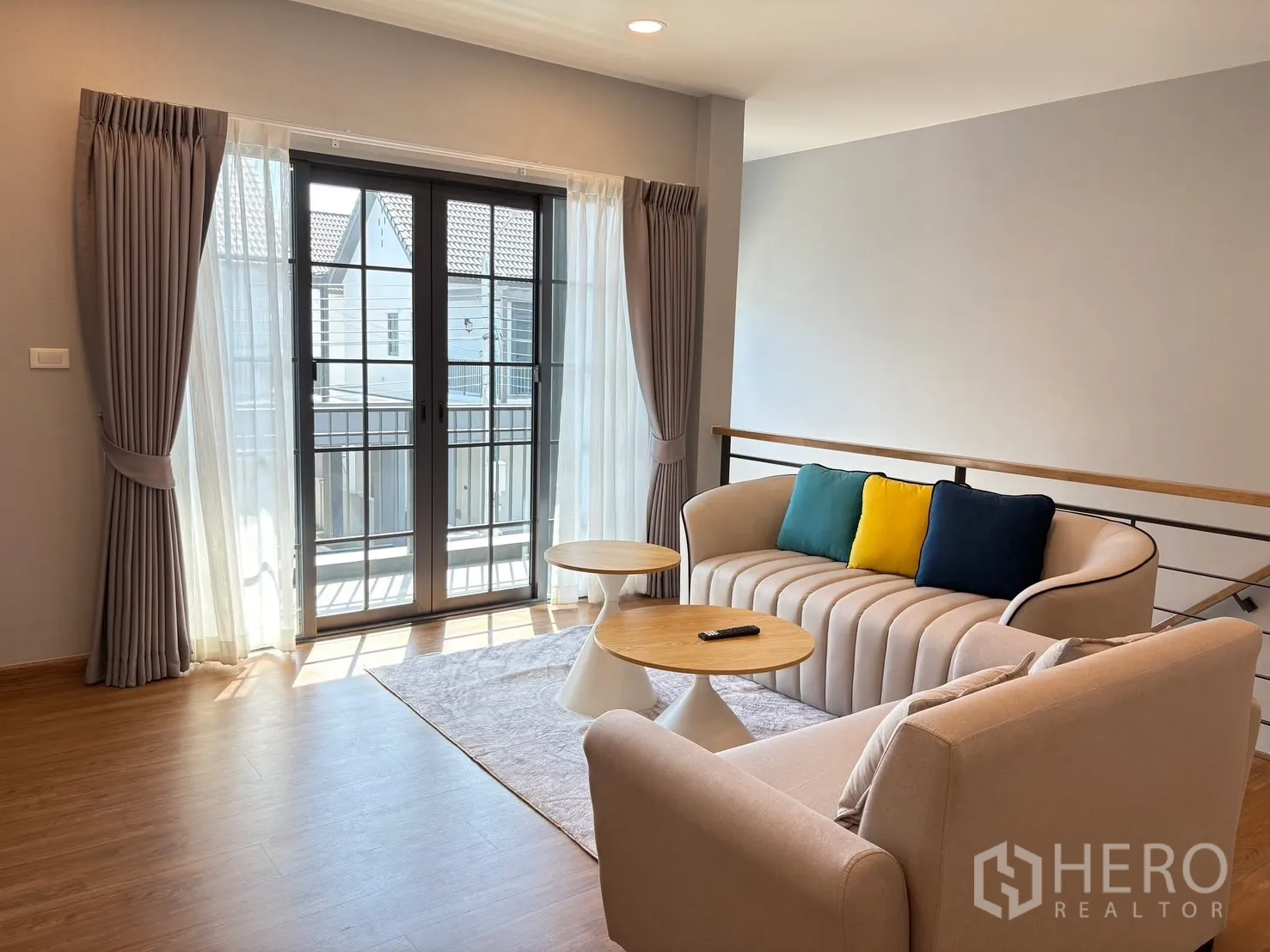 Detached House for rent in Bang Phli, Samut Prakan - Upper lounge with twin sofas, round coffee tables and balcony doors with layered curtains.