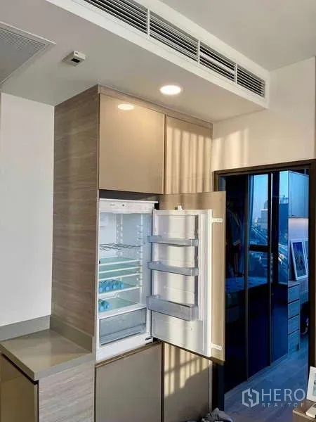 Condominium for rent - Modern kitchen with integrated refrigerator and access to a small balcony, city views beyond.