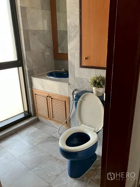 คอนโด ให้เช่าในWatthana, Bangkok - ห้องน้ำกะทัดรัด โถสุขภัณฑ์และอ่างล้างมือสีน้ำเงิน ใกล้หน้าต่างฝ้า