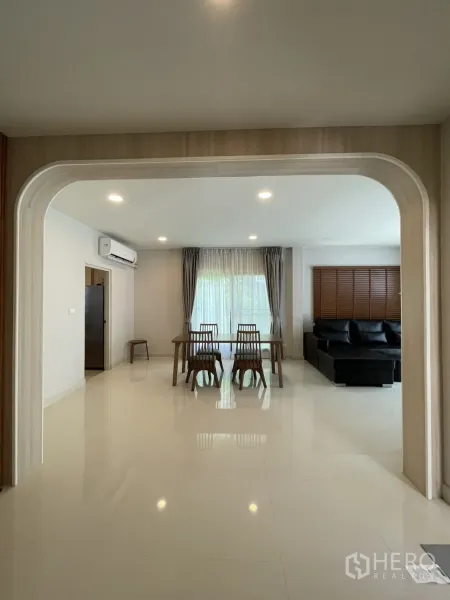 Detached House for rent in Bang Phli, Samut Prakan - Arched entry framing the dining set and bright lounge with large windows.