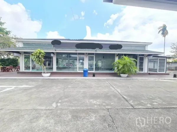 พื้นที่ขายปลีก ให้เช่าในPrawet, Bangkok - มุมมองด้านหน้าอาคารพื้นที่ร้านค้า ประตูกระจกบานเลื่อน กันสาด กระถางต้นไม้ และพื้นที่จอดรถกว้าง