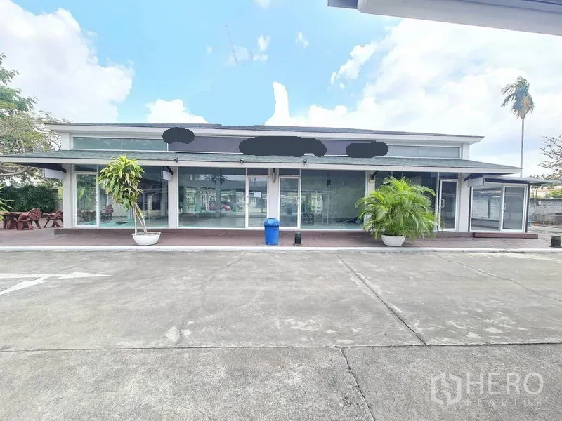 พื้นที่ขายปลีก ให้เช่าในPrawet, Bangkok - มุมมองด้านหน้าอาคารพื้นที่ร้านค้า ประตูกระจกบานเลื่อน กันสาด กระถางต้นไม้ และพื้นที่จอดรถกว้าง