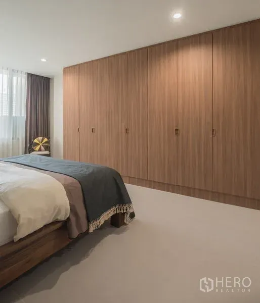 คอนโด ให้เช่าในKhlong San, Bangkok - ห้องนอนใหญ่พร้อมตู้เสื้อผ้าไม้ยาวตลอดผนังและไฟฝังเพดานโทนอุ่น