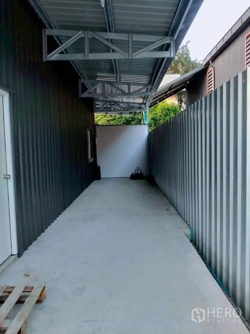 货栈 for rent in Lat Phrao, Bangkok - 仓库侧边带顶装卸通道，金属墙面与混凝土走道。