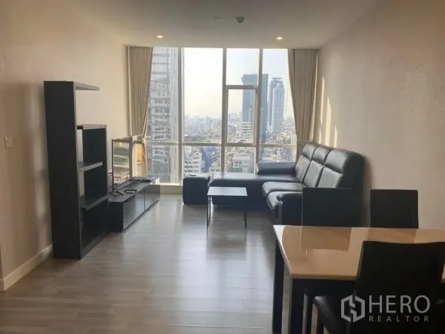 คอนโด ให้เช่าหรือขายในBang Rak, Bangkok - ห้องนั่งเล่นโซฟาเข้ามุมสีดำ ชั้นวางของ และหน้าต่างบานใหญ่ชมวิวกรุงเทพฯ