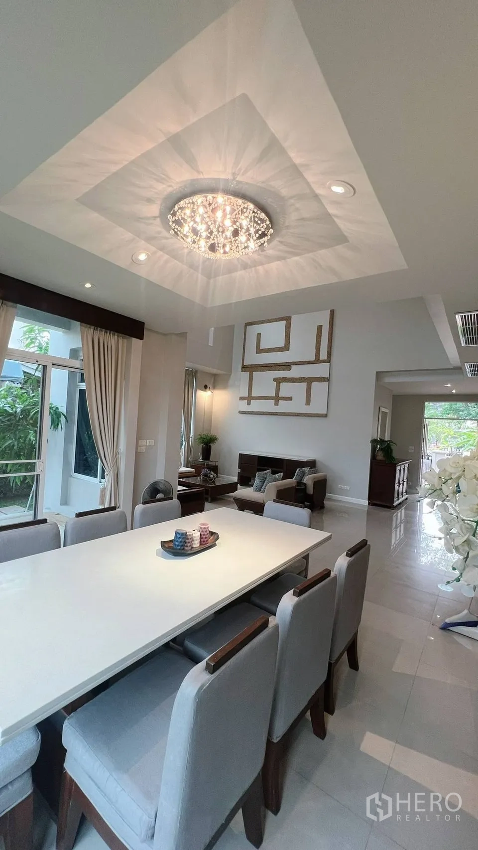 Detached House for rent in Lat Krabang, Bangkok - Dining area with long table, chandelier and views to the living room.