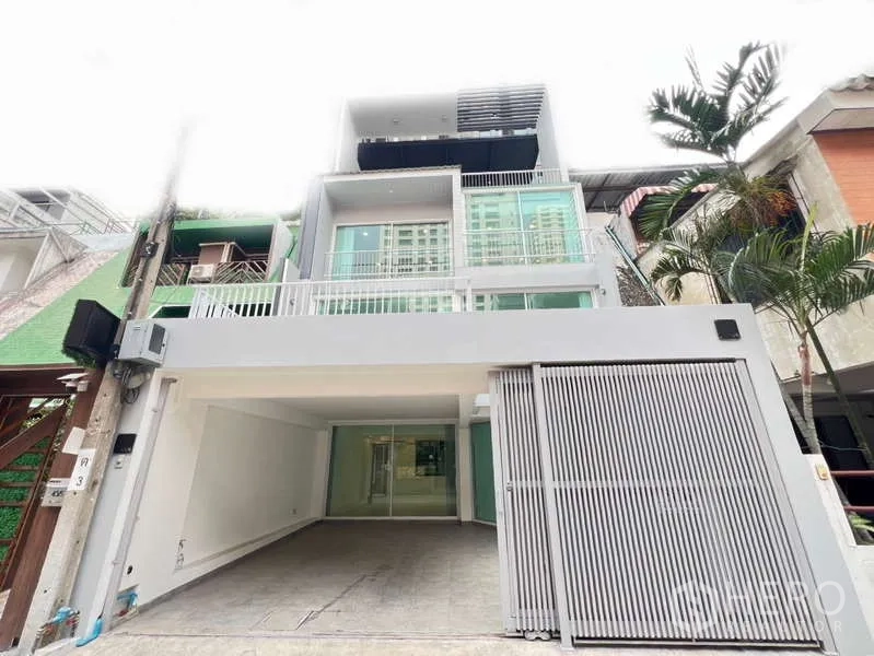 带办公室的家 出租在Khlong Toei, Bangkok - 临街现代联排外观，带栅栏车位与阳台。