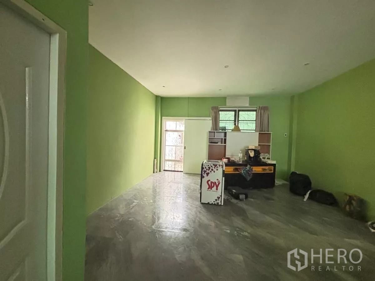 店屋 出租在Watthana, Bangkok - 一层开放空间，绿色墙面与光洁地面，带后窗采光。