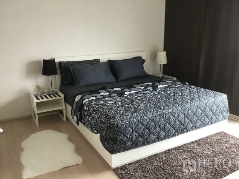 公寓 出租或出售在Watthana, Bangkok - 宽敞卧室配大床、床头柜与柔软地毯，靠近大窗。