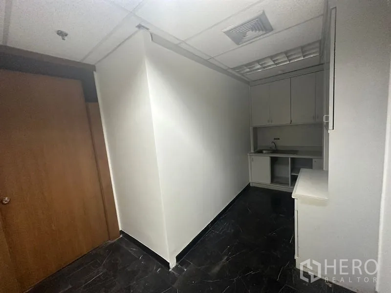 办公空间 出租在Pathum Wan, Bangkok - 办公室内小型茶水间，内置橱柜、水槽与深色地砖。