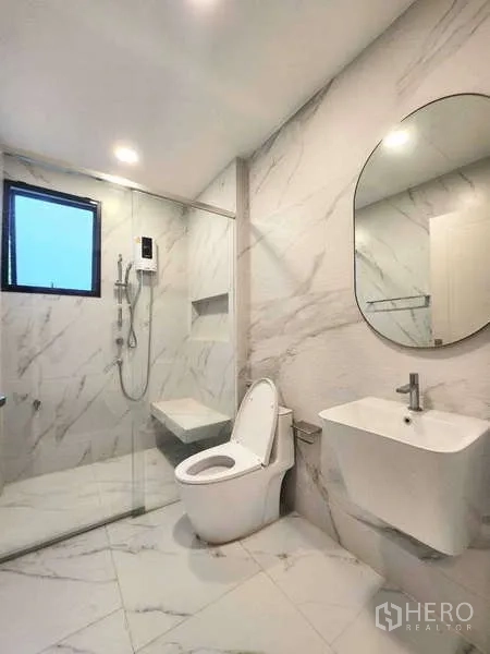 Detached House for rent in Saphan Sung, Bangkok - Modern bathroom with glass shower enclosure, rain shower set and marble-look tiles.