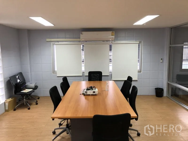 Factory for sale in Pathum Thani - Air‑conditioned meeting room with long table, chairs and a projector.