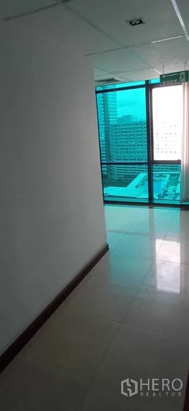 Office Space for rent in Huai Khwang, Bangkok - Passage leading to a windowed nook with skyline views and an exit sign.