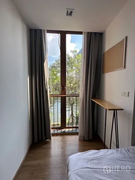 公寓 出租在Watthana, Bangkok - 窄长角落的高窗与法式阳台，可见绿树景观