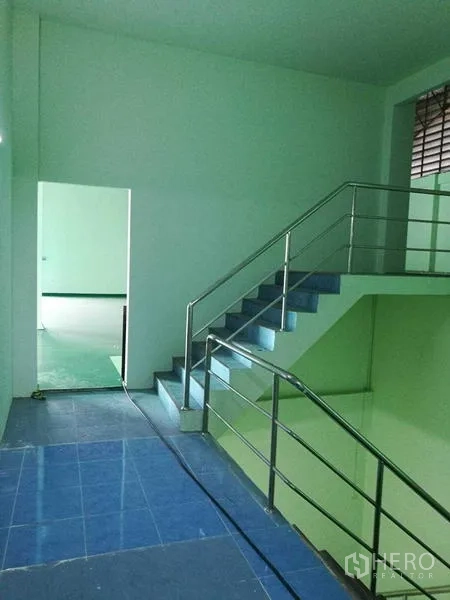 Factory for rent in Mueang Samut Sakhon, Samut Sakhon - Upper-floor landing with blue tiles and railing next to a large work zone.