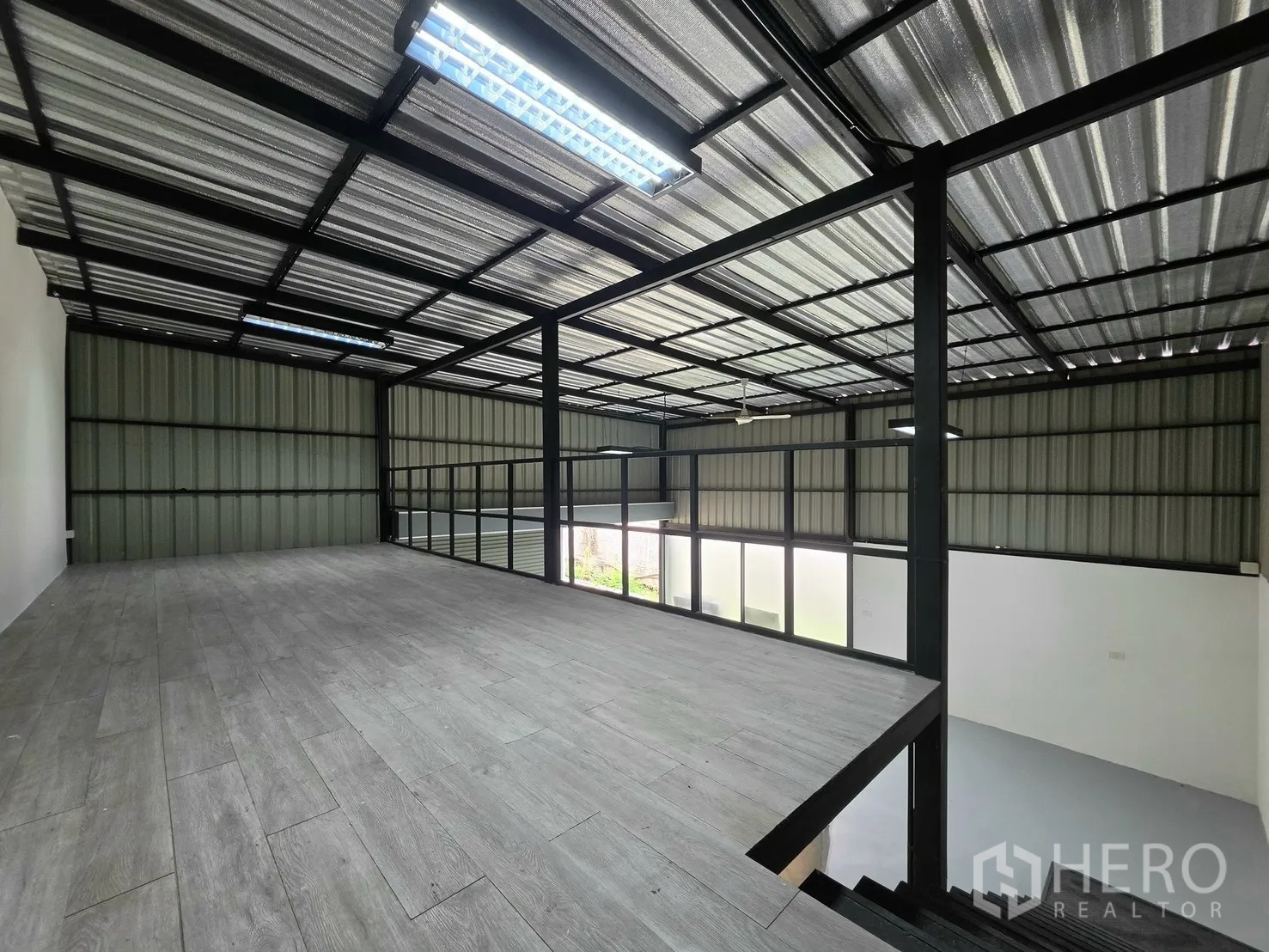Warehouse for rent in Suan Luang, Bangkok - Mezzanine level with wood-look flooring and safety railing overlooking the floor.