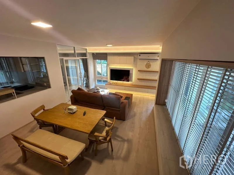 独立式住宅 出租在Prawet, Bangkok - 客餐一体开放空间，暖色木地板与百叶窗。