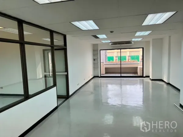 办公空间 出租在Pathum Wan, Bangkok - 明亮开放式办公室，抛光地面、荧光灯、壁挂空调，推拉玻璃门通向阳台。