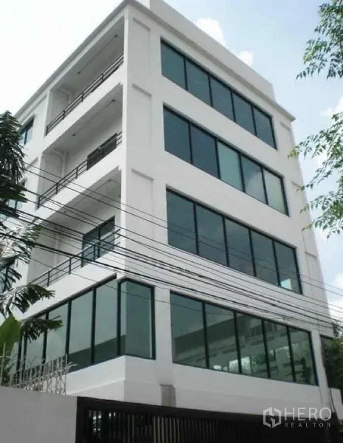 Home Office for rent or sale in Wang Thonglang, Bangkok - Modern white mid-rise office building with large windows and balconies.