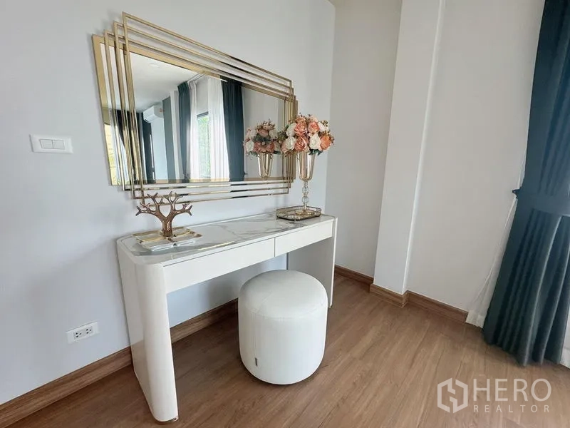 Detached House for rent or sale in Bang Phli, Samut Prakan - Elegant dressing table with gold-framed mirror and floral decor in a bedroom corner.
