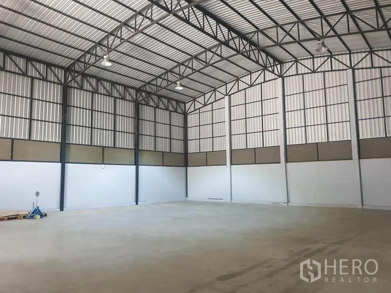 Warehouse for rent in Bang Kapi, Bangkok - Spacious warehouse interior with high steel truss roof, concrete floor and ample lighting.