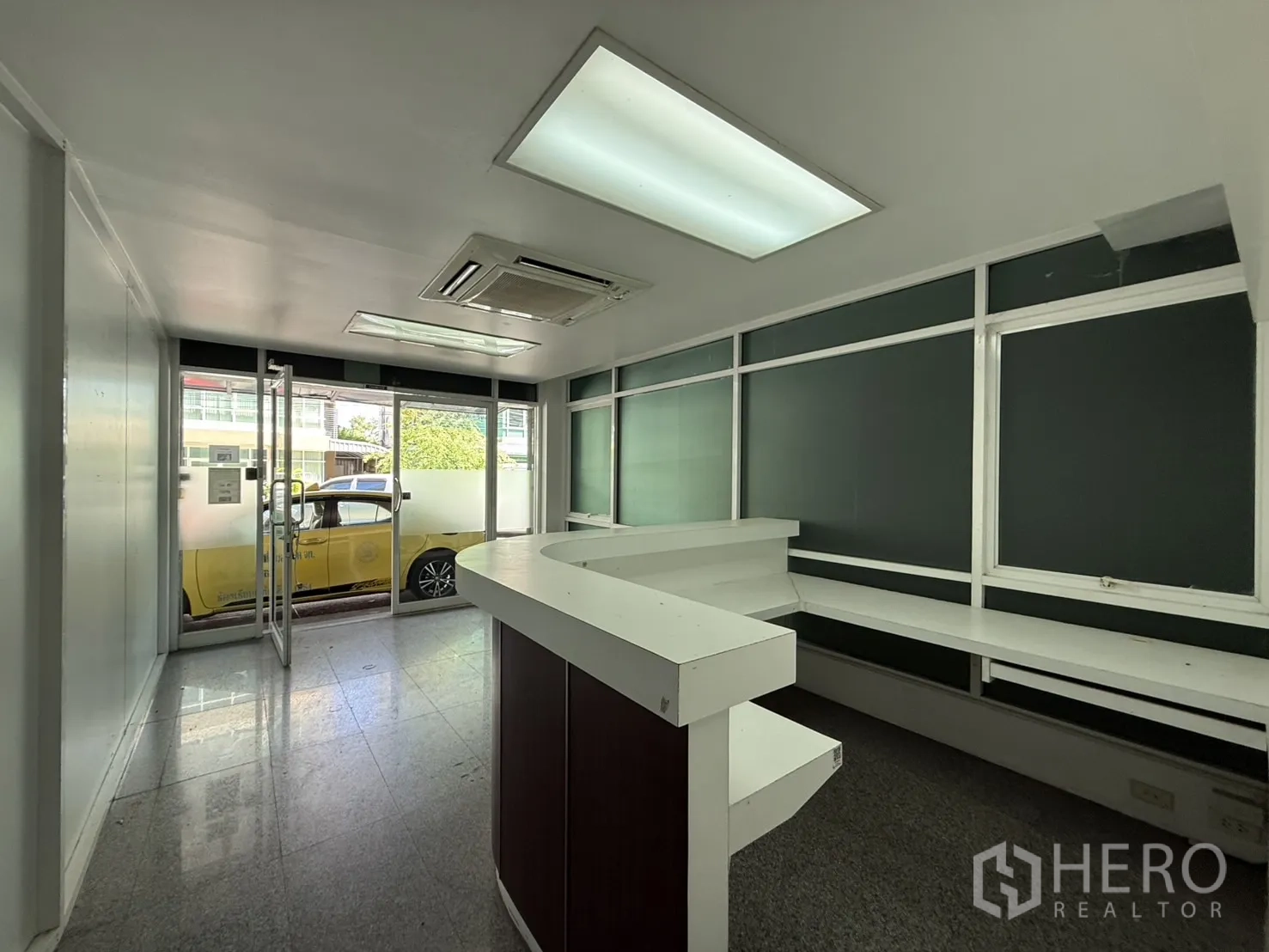 Office Space for rent in Bueng Kum, Bangkok - Reception area facing the glass entrance with built-in work counter and ceiling AC.