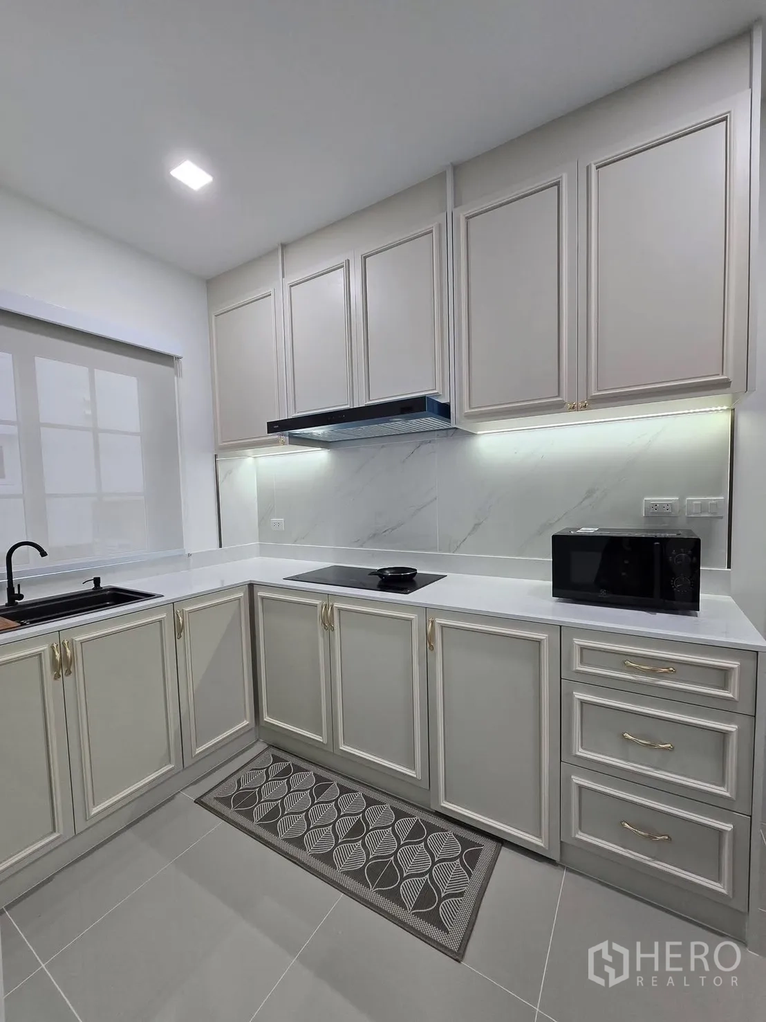 บ้านแฝด for rent in Mueang Samut Prakan, Samut Prakan - ครัวรูปตัว U มีเตาไฟฟ้า ไฟใต้ตู้ และตู้บานลูกฟักสไตล์คลาสสิก