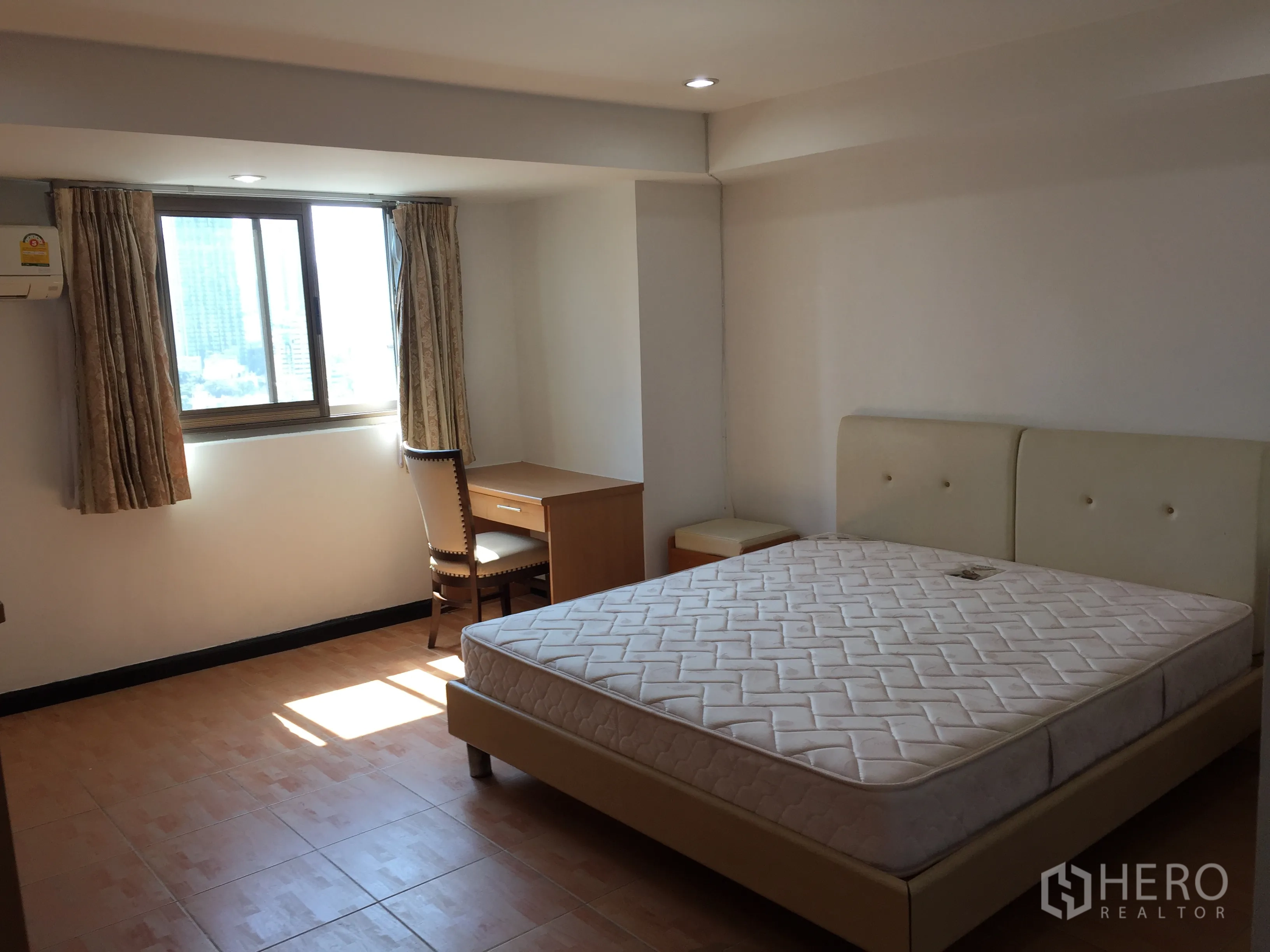 Condominium for rent in Watthana, Bangkok - Bright bedroom with large window, bed, and study desk offering a city view.
