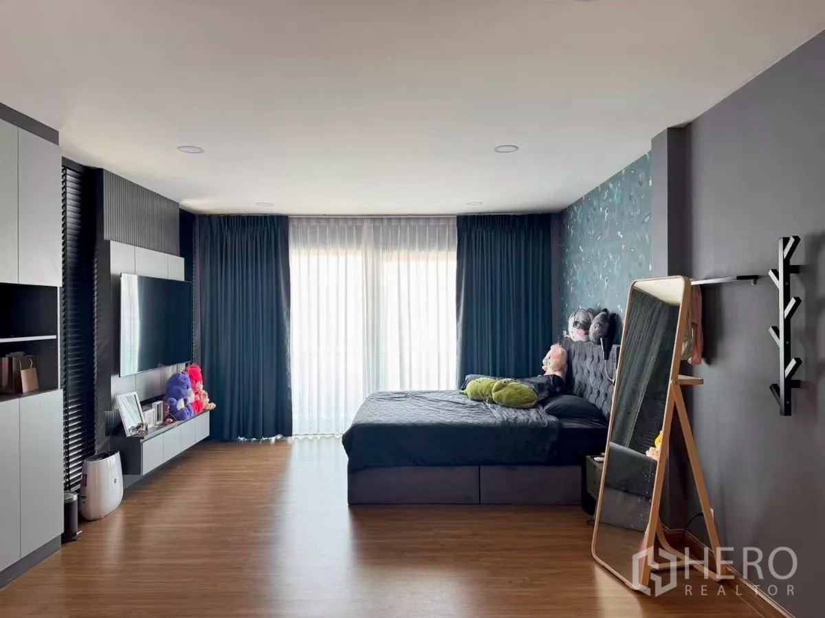 Detached House for rent in Bang Phli, Samut Prakan - Spacious master bedroom with TV unit, large bed and floor-to-ceiling curtains to balcony.