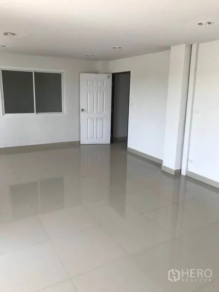 Factory for rent or sale in Mueang Samut Sakhon, Samut Sakhon - Bright office room with glossy tile flooring, window and hinged door.